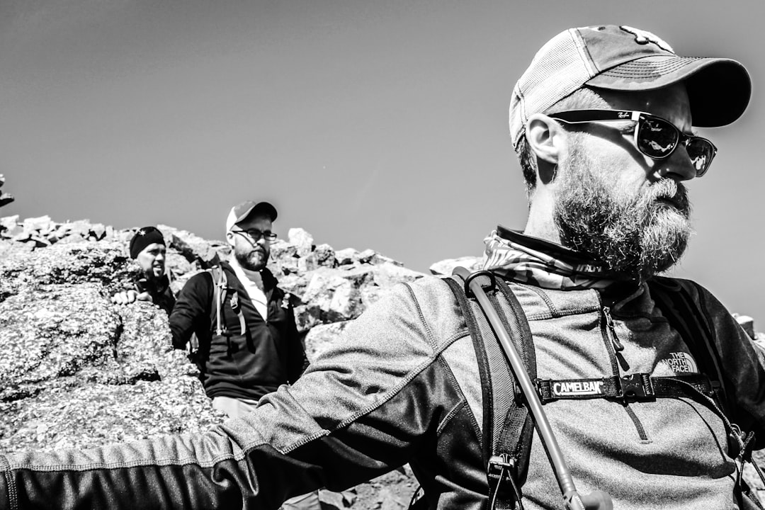 Fotografia Em Tons De Cinza De Homens Caminhando Perto De Formacoes Rochosas 83CMBPHD PU