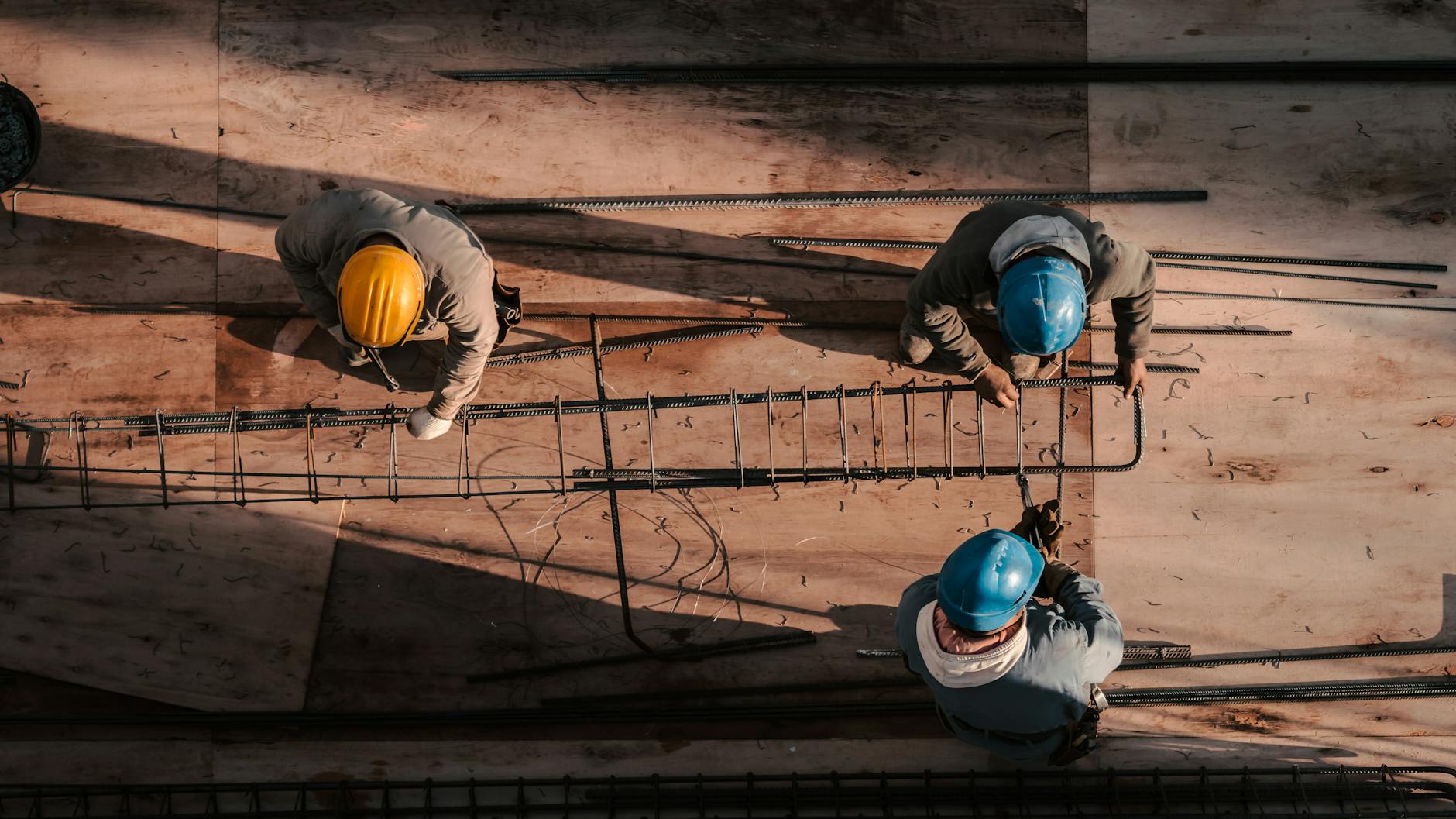 Top view of workers in hard hats assembling steel bars on a construction site in Buenos Aires.
