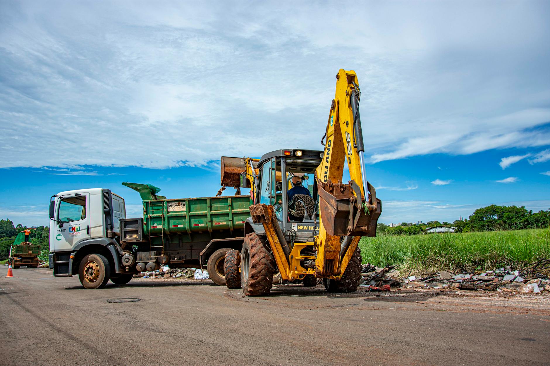 Excavator and truck clearing rubble in Londrina, Brazil outdoors.