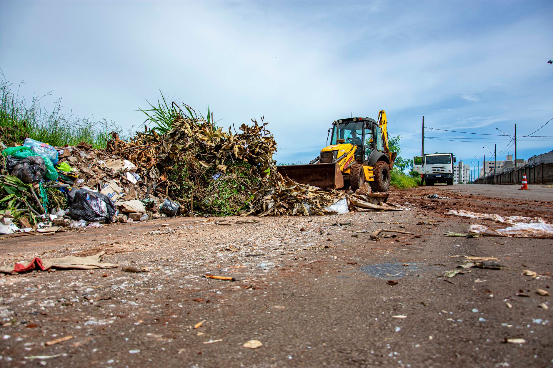 Street cleaning operation with bulldozer and debris in Londrina, Brazil.