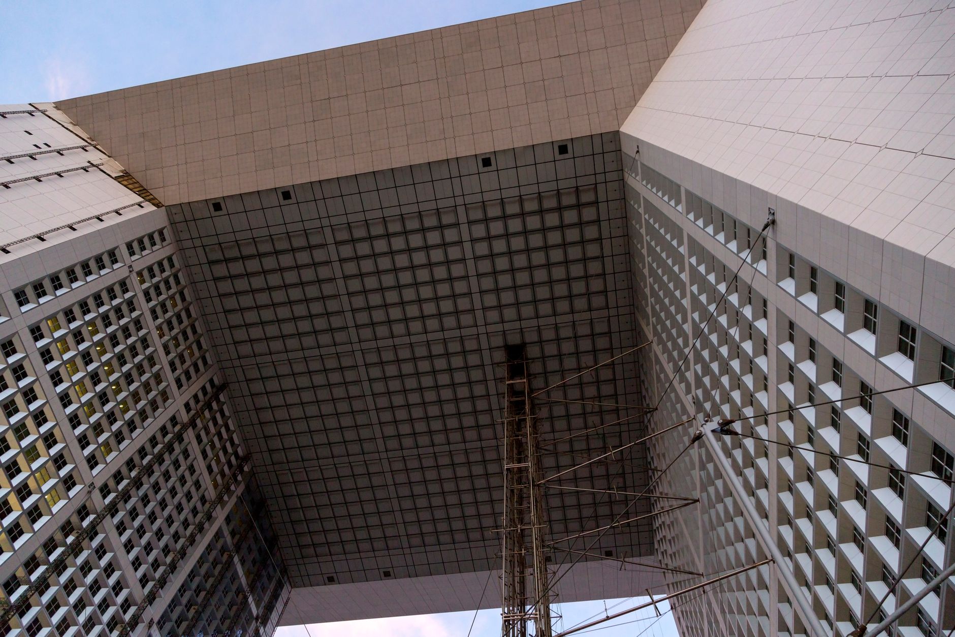 Stunning low angle view of a modern architectural structure with geometric patterns against the sky.