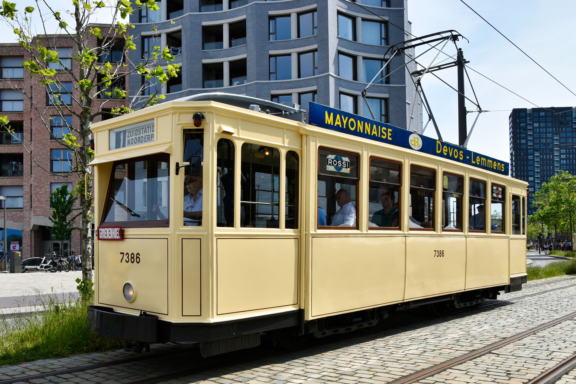 A vintage tram travels through Antwerp, Belgium, against modern architecture. Vibrant and historic charm.