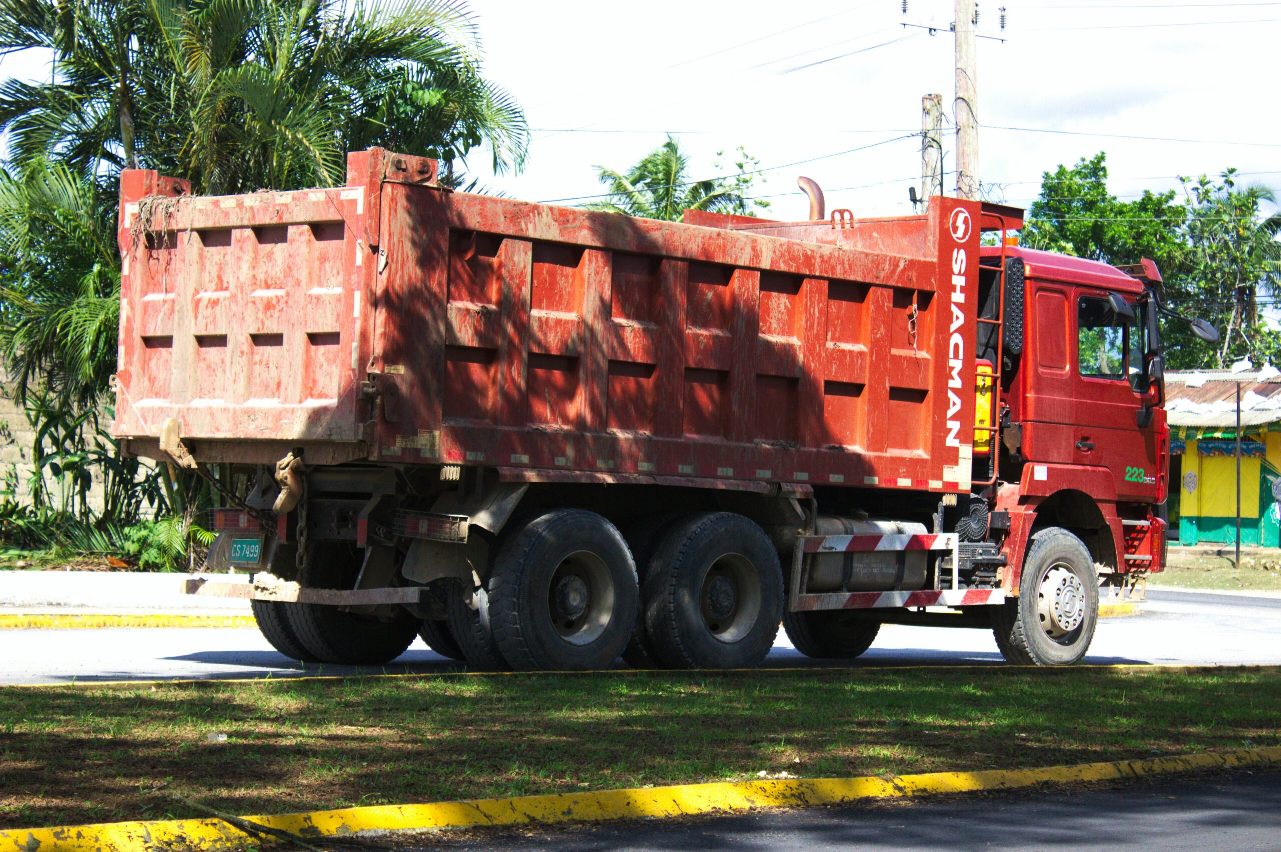 Red dump truck parked on a road.
